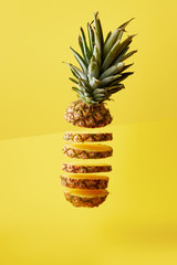 Wall Mural - close up view of cut pineapple exotic fruit on yellow background