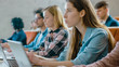 © Gorodenkoff - Large Group of Multi Ethnic Students Working on the Laptops while Listening to a Lecture in the Modern Classroom. Bright Young People Study at University.