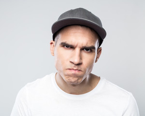 Wall Mural - Portrait of angry young man in baseball cap