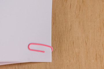 Blank paper clipped on wooden desk. Office workplace. Mockup for design. 