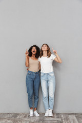 Wall Mural - Full length portrait of two cheerful young women