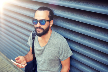 Sticker - travel, tourism, communication, technology and people concept - man with backpack texting on smartphone on city street