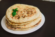 tortillas with potatoes, pita, chapati, decorated with a leaf of basil, on a black background, oriental food