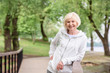 © LIGHTFIELD STUDIOS - smiling senior woman standing near railings in park