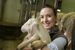 © goodluz - Farmer woman carrying lamb in arms