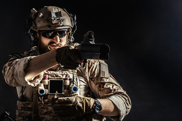 Wall Mural - Special forces soldier with rifle on dark background