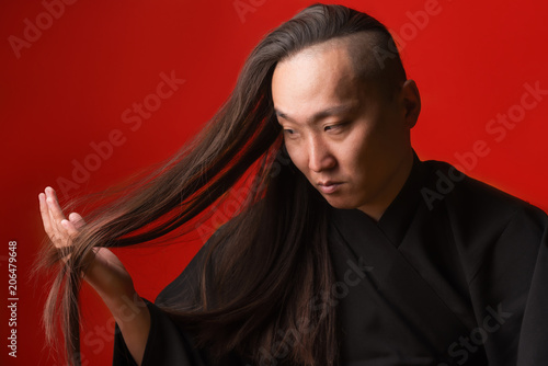 Asian Man With Long Thick Hair On A Red Background Buy This