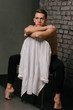 © Skripnik Olga - Casually handsome. Studio shot of handsome young man sitting on the chair and looking at camera. white shirt hanging on a chair