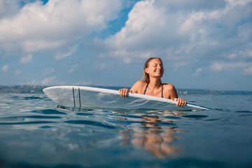 Wall Mural - Happy surf woman with surfboard. Professional surfer with surfboard in ocean