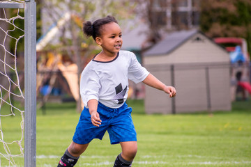 Wall Mural - A young girl is learning how to play soccer	