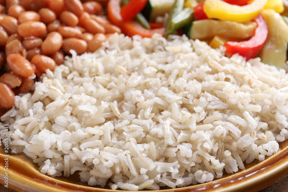 Brown rice with beans and vegetables on plate, closeup