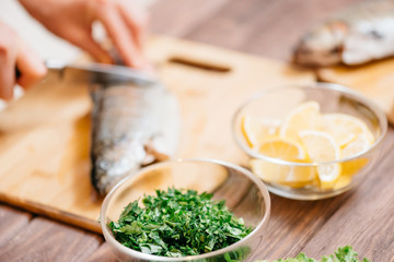 Wall Mural - Woman cutting raw fish in the kitchen.