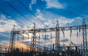 Sunset behind substation towers with blue sky