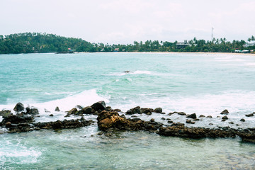 Beach on the Mirirsa Sri Lanka with the Governors offices and the Latte of Freedom on the right, Hagatna beyond that, and Two Lovers Point center right.