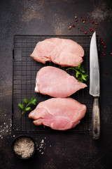 Raw meat of turkey steak on dark old background. Top view.