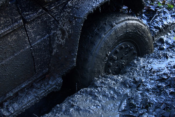 Fragment of offroad car stuck in dirt, close up.