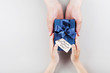 © juliasudnitskaya - Son and daddy holding a gift or present box with tag on Happy fathers day. Holiday concept top view.