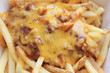 Chili Cheese Fries American Fast Food Dish Close Up. French Fries Covered in Beef Chili Sauce and Cheese, Traditional American Snack Meal in Many Fast Food Restaurants. Chili Cheese Fries Top View.