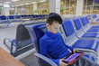 © Michael - boy in an empty airport one waits for the plane and plays in his favorite gadget