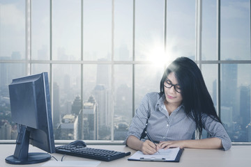 Wall Mural - Female employee writing on the paperwork