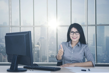 Wall Mural - Female worker showing OK sign near the window