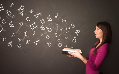 Wall Mural - Casual young woman holding book with white alphabet flying out of it