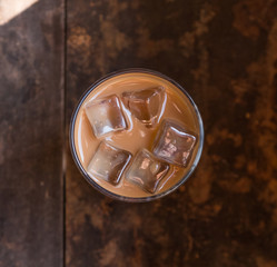 Wall Mural - Iced milk coffee over wooden background