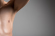 © Yakobchuk Olena - Close up half of torso of young man with smooth armpit. He is standing with raised arm against light wall and demonstrating his hairless underarm. Laser hair removal concept. Copy space in right side