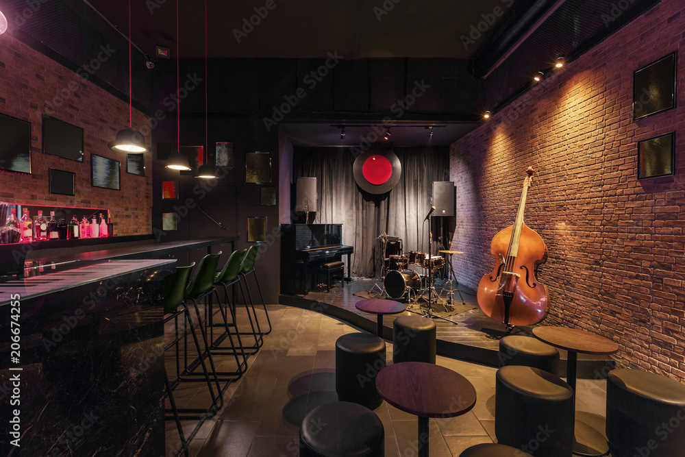 Modern jazz bar interior design, stage with black piano and cello, lamps above bar counter - obrazy, fototapety, plakaty 