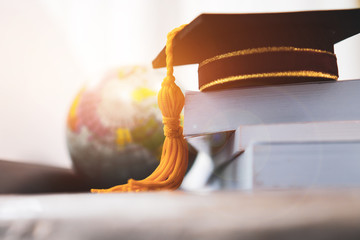 graduated or graduation university study abroad international conceptual, master cap on books stack 