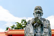 closeup old statue of confucius with soft-focus and over light in the background