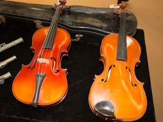 two violins waiting for restoration at a craftsman