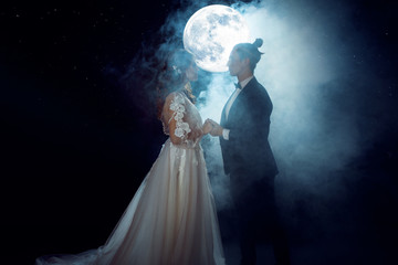 Wall Mural - Mysterious and romantic meeting, the bride and groom under the moon. Hugs together. Mixed media