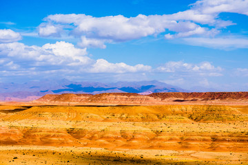 Wall Mural - Picturesque landscape with orange sand dunes and mountains in Sahara desert with bright blue sky and clouds in Morocco