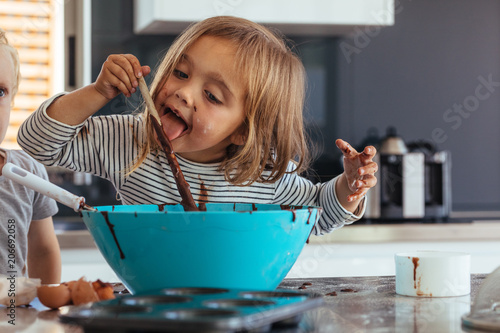 Fotomural Girl licking chocolate cream while baking