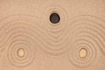 Wall Mural - Three stone lies in the center of a circle of sand. Texture of sand.