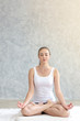 © thbangkok - Young caucasian very attractive woman practicing yoga, sitting in Padmasana doing yoga exercise or Lotus pose or namaste pose. Working out on her bed.