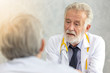 © thbangkok - Senior medical doctor or chief doctor giving a consultation to her male patient and explaining medical informations and diagnosis at the clinic or hospital.