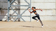 © Artem Varnitsin - Full length shot of young female athlete sprinting in city. Slim woman running in the morning.