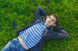 © bravissimos - Portrait, cute teen boy listening music, lying down on fresh green grass