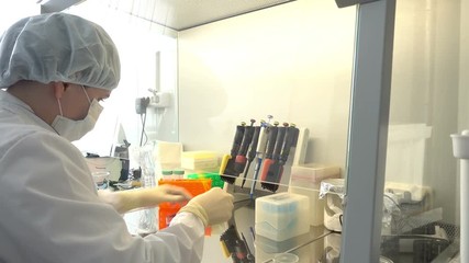 Canvas Print - NOVOSIBIRSK RUSSIA, - APRIL 16 2017: Young scientist working in a safety laminar air flow cabinet at laboratory