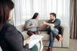© Nomad_Soul - Couple sitting on sofa, psychologist reception