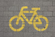 © yos_moes - Yellow sign of a bicycle path drawn on the asphalt road. Lanes for cyclists. Cyclist on urban cycleway. Traffic signs and road safety.