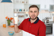 © New Africa - Young man with glass of tasty milk at home
