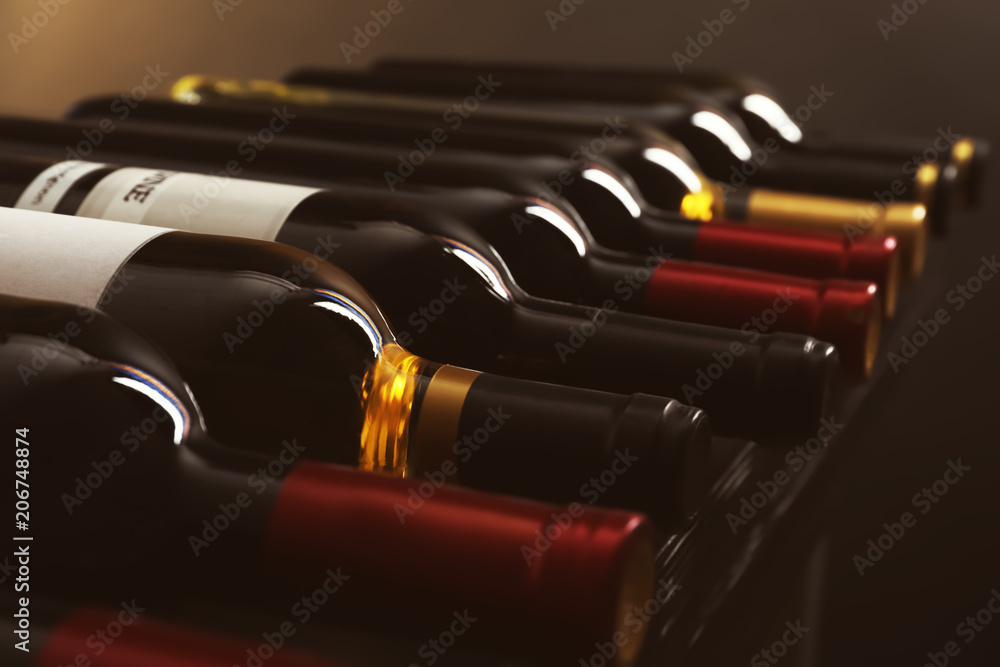 Bottles with delicious wine on shelf, closeup. Professional sommelier - obrazy, fototapety, plakaty 