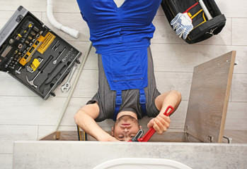 Poster - Professional plumber with set of tools working indoors, top view