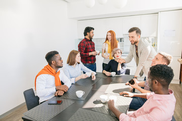 Wall Mural - Caucasian bearded guy is debating with black man during the break at work