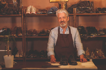 Wall Mural - An elderly shoemaker in studio