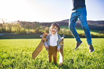 Wall Mural - Happy toddler boy playing outside with father in spring nature.