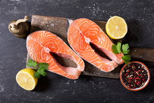 fresh salmon steaks with ingredients for cooking, top view
